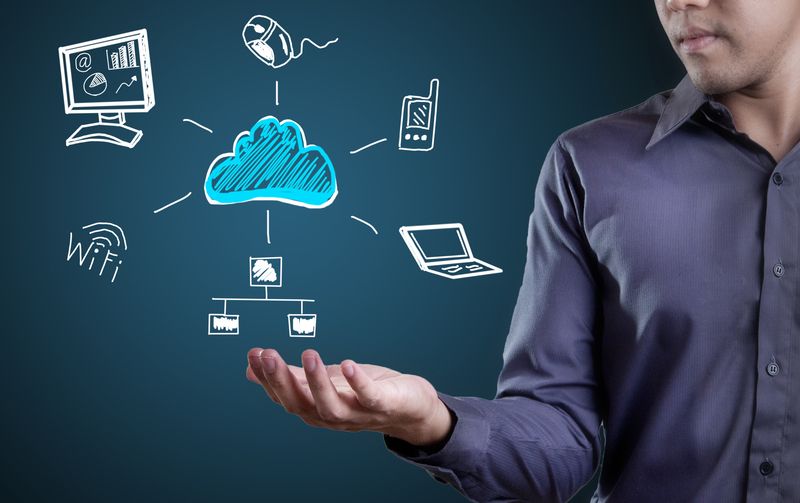 Technology concept with man holding computer, network and other things surrounded by cloud
