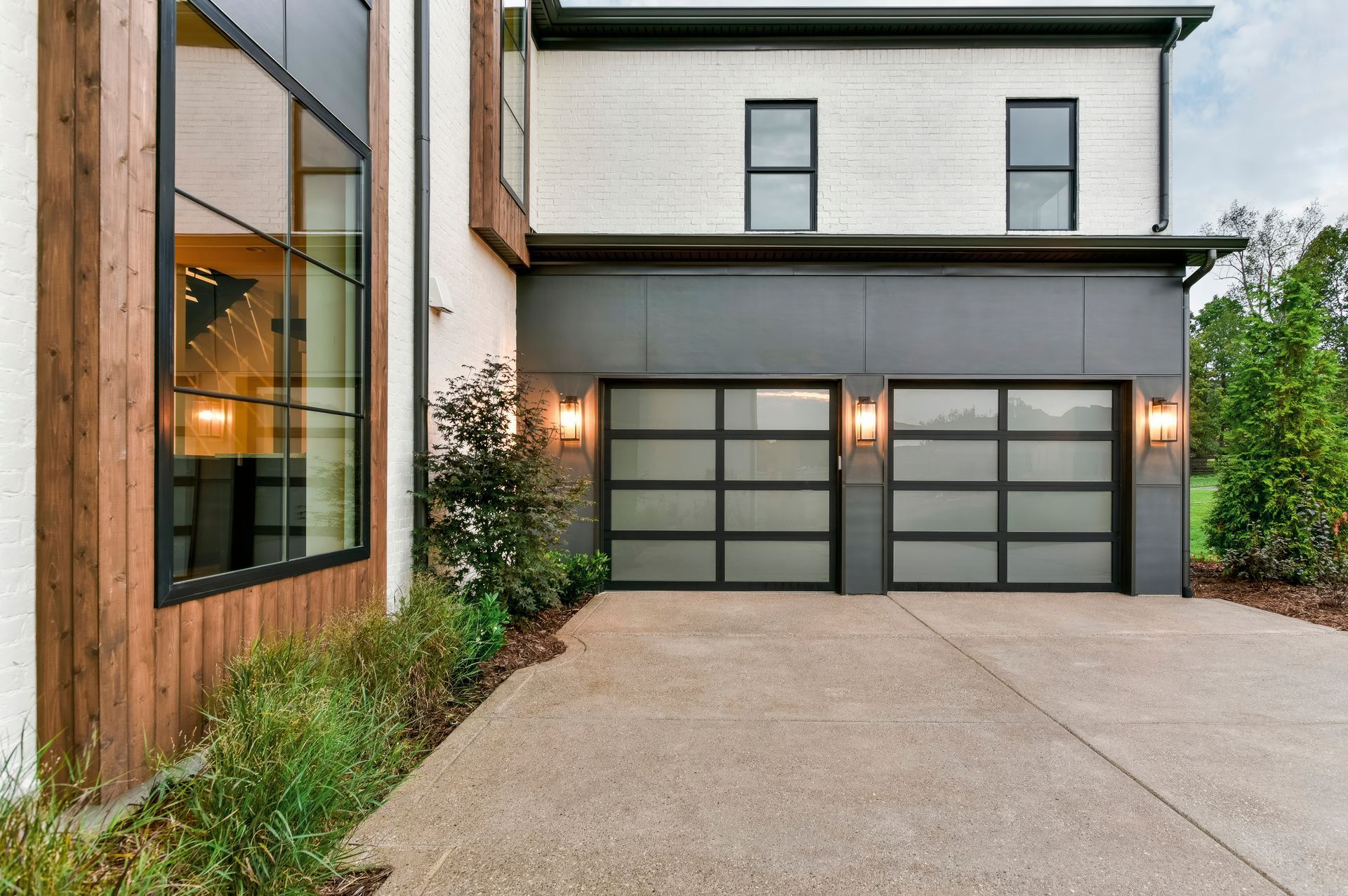 A row of wooden garage doors with windows on a house.