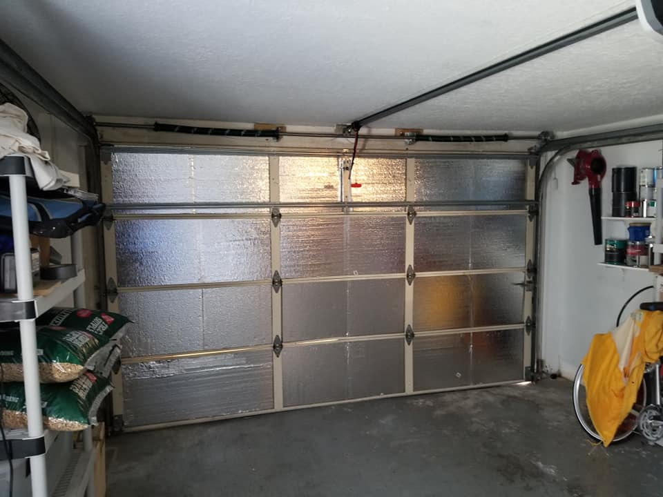 A garage with a garage door that is covered in insulation.