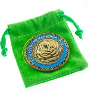 A coin in a green bag that says portland marathon 2013