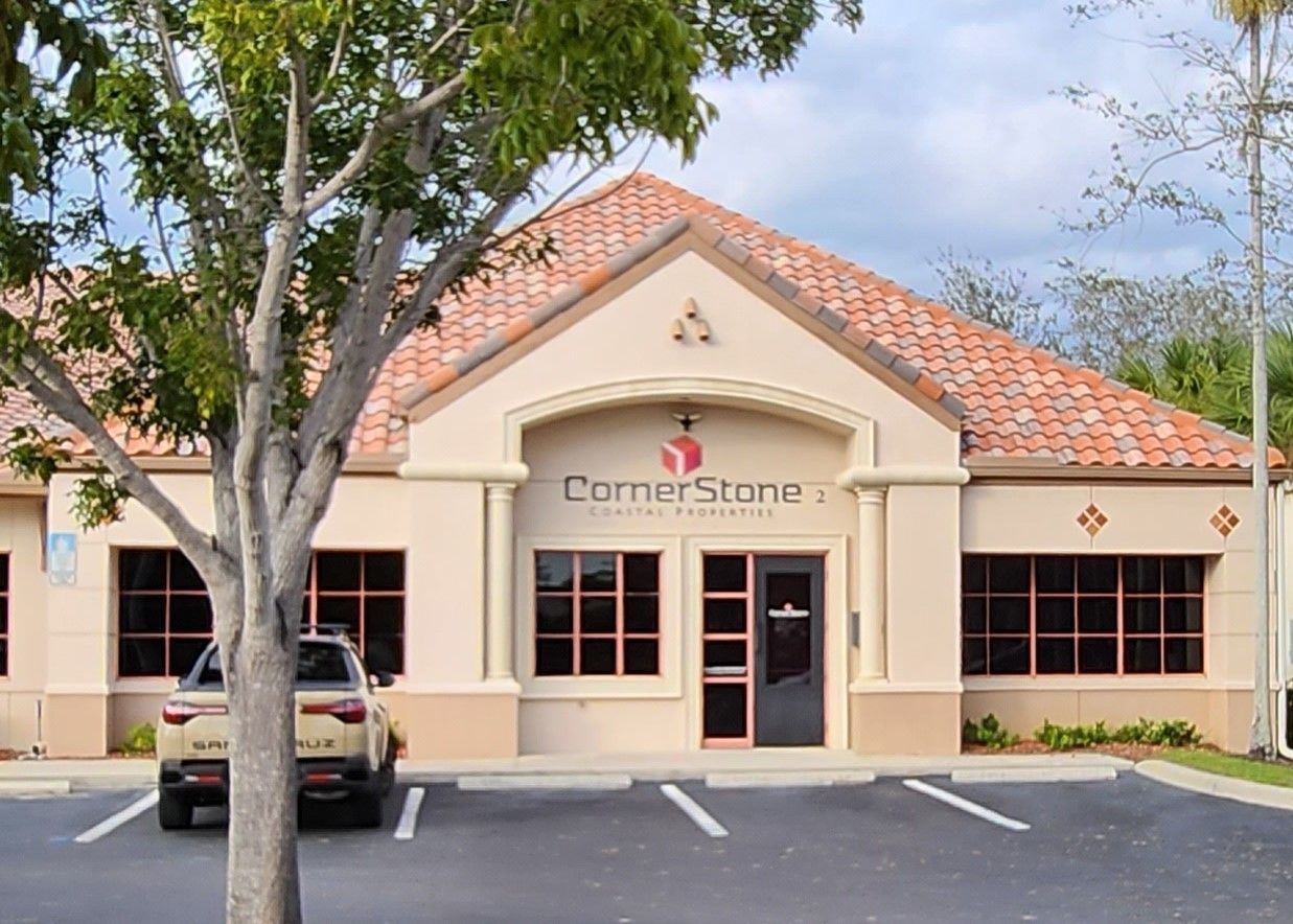 A car is parked in front of a building that says cornerstone