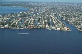An aerial view of a city surrounded by water and houses.
