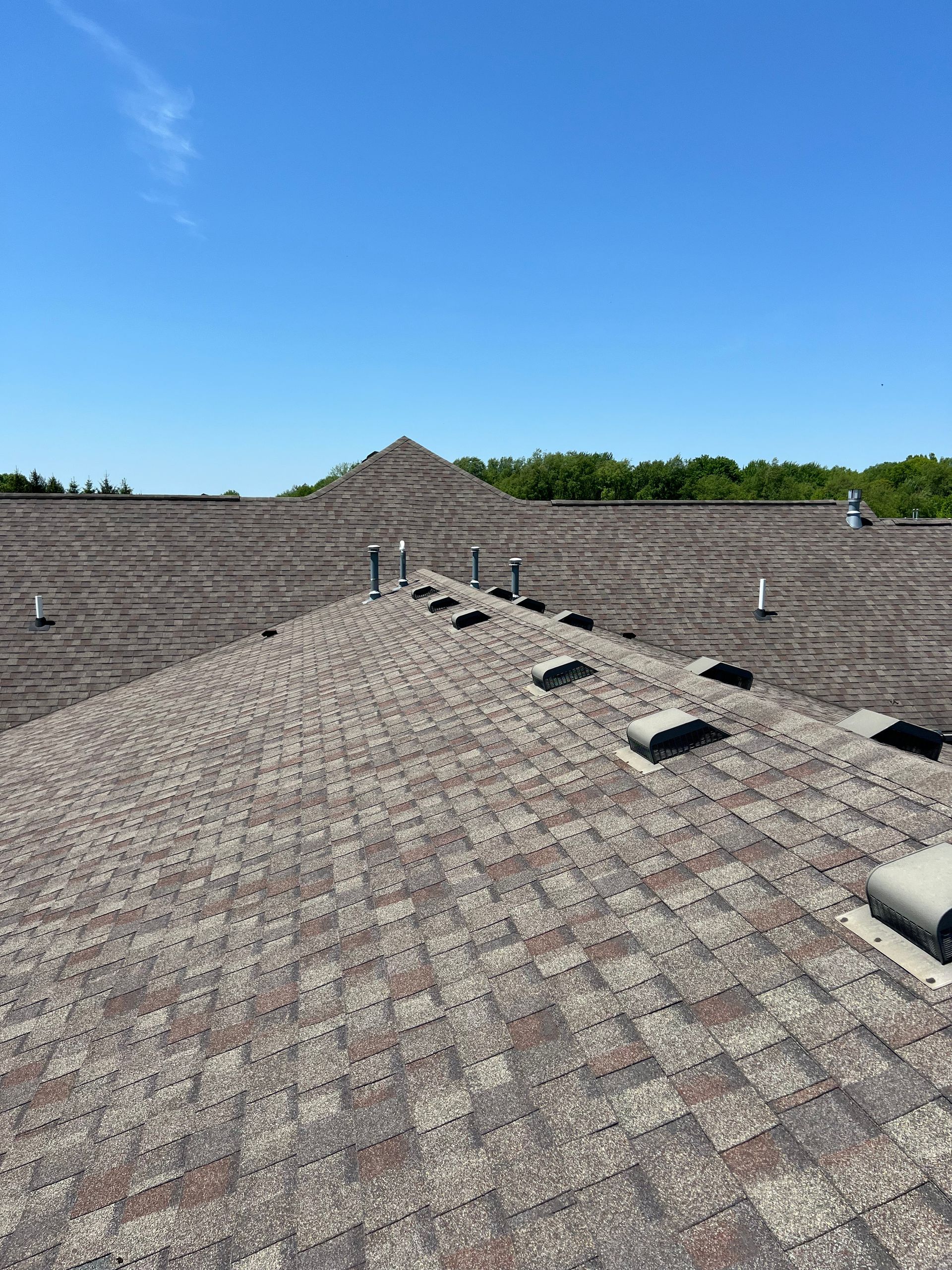 Aerial view of a residential asphalt shingle roof inspected for hail damage after a storm