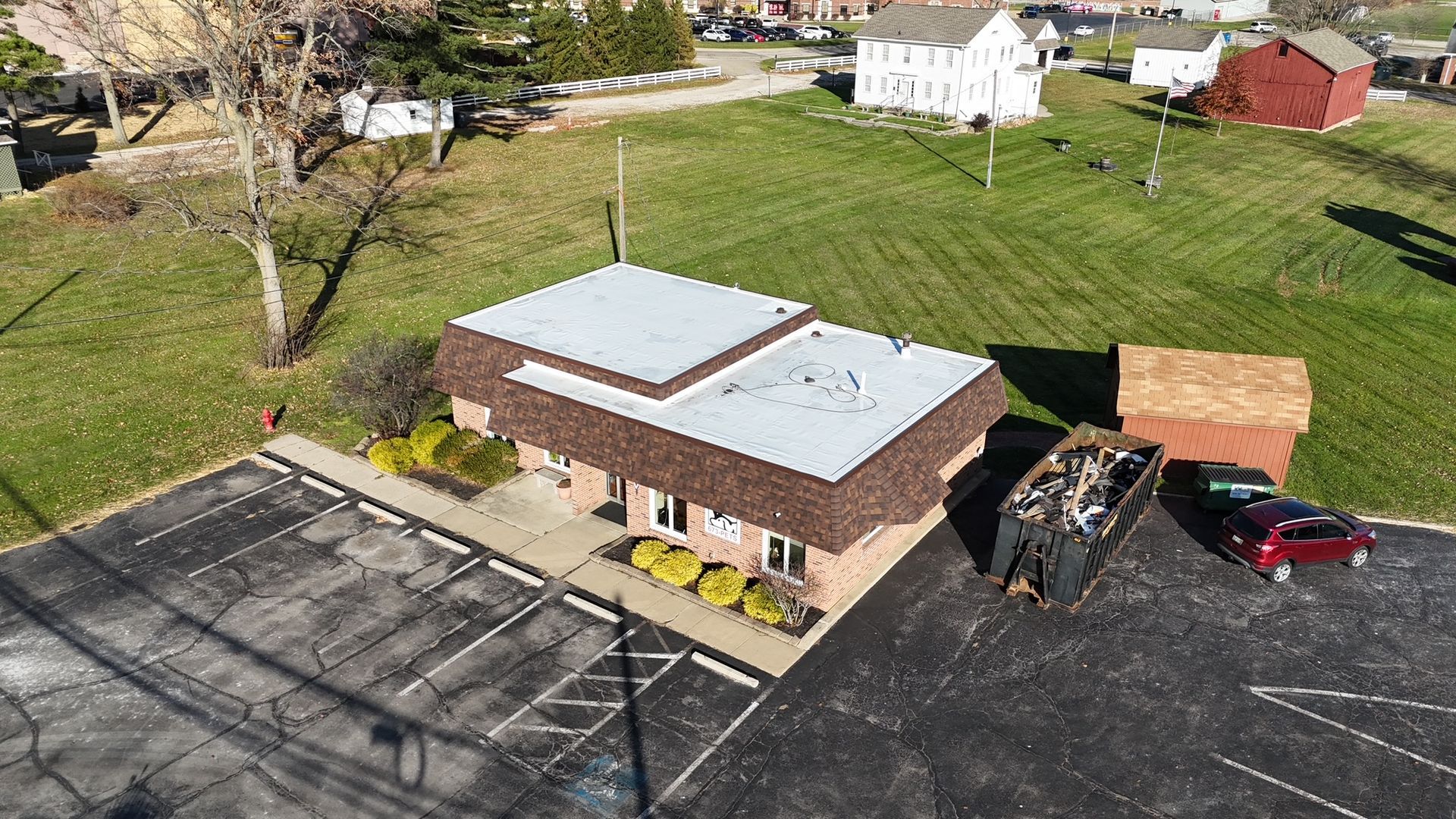 Damaged asphalt shingle roof with missing and torn areas.