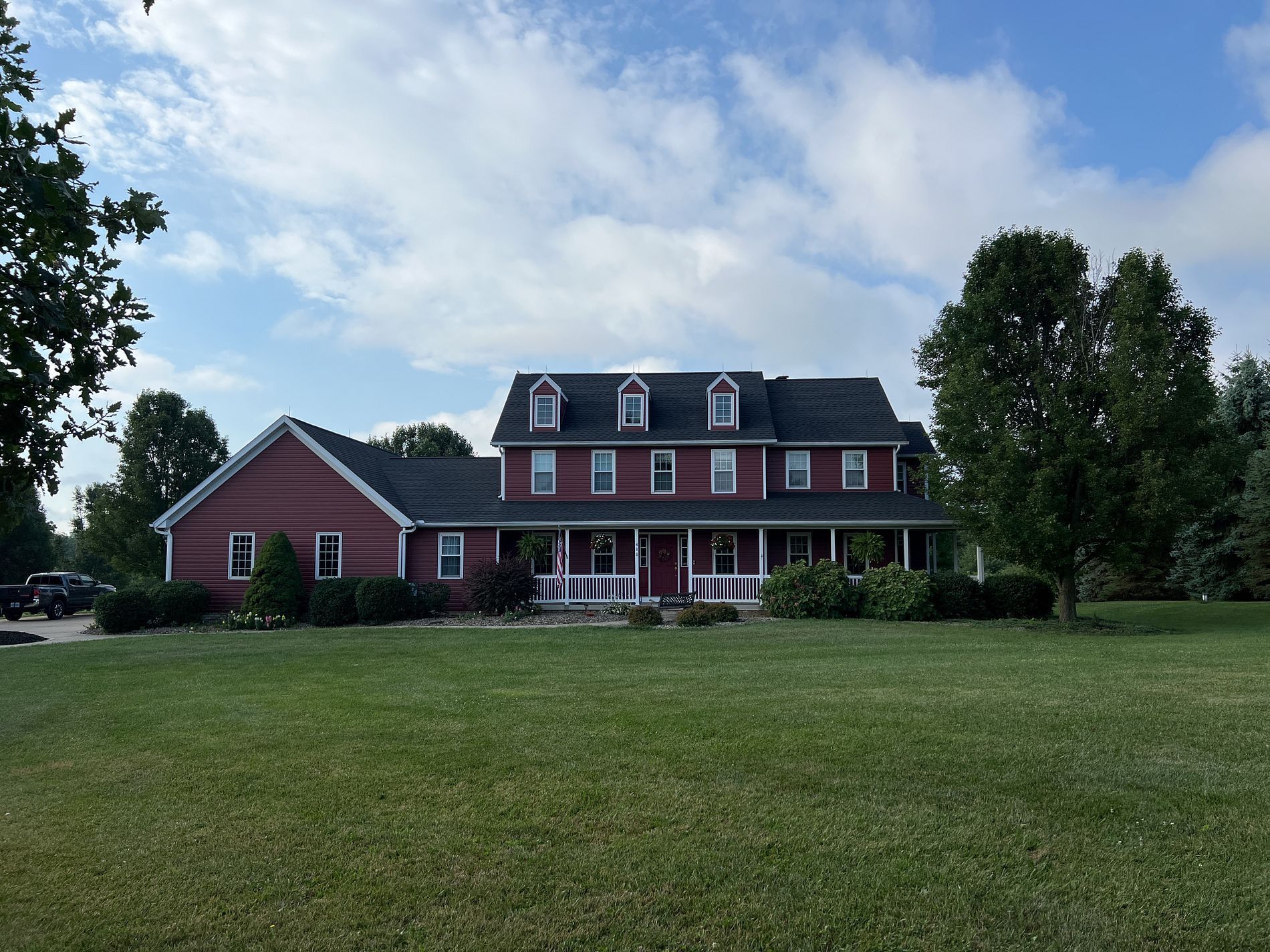 Red home with new siding installation and updated exterior showing improved curb appeal
