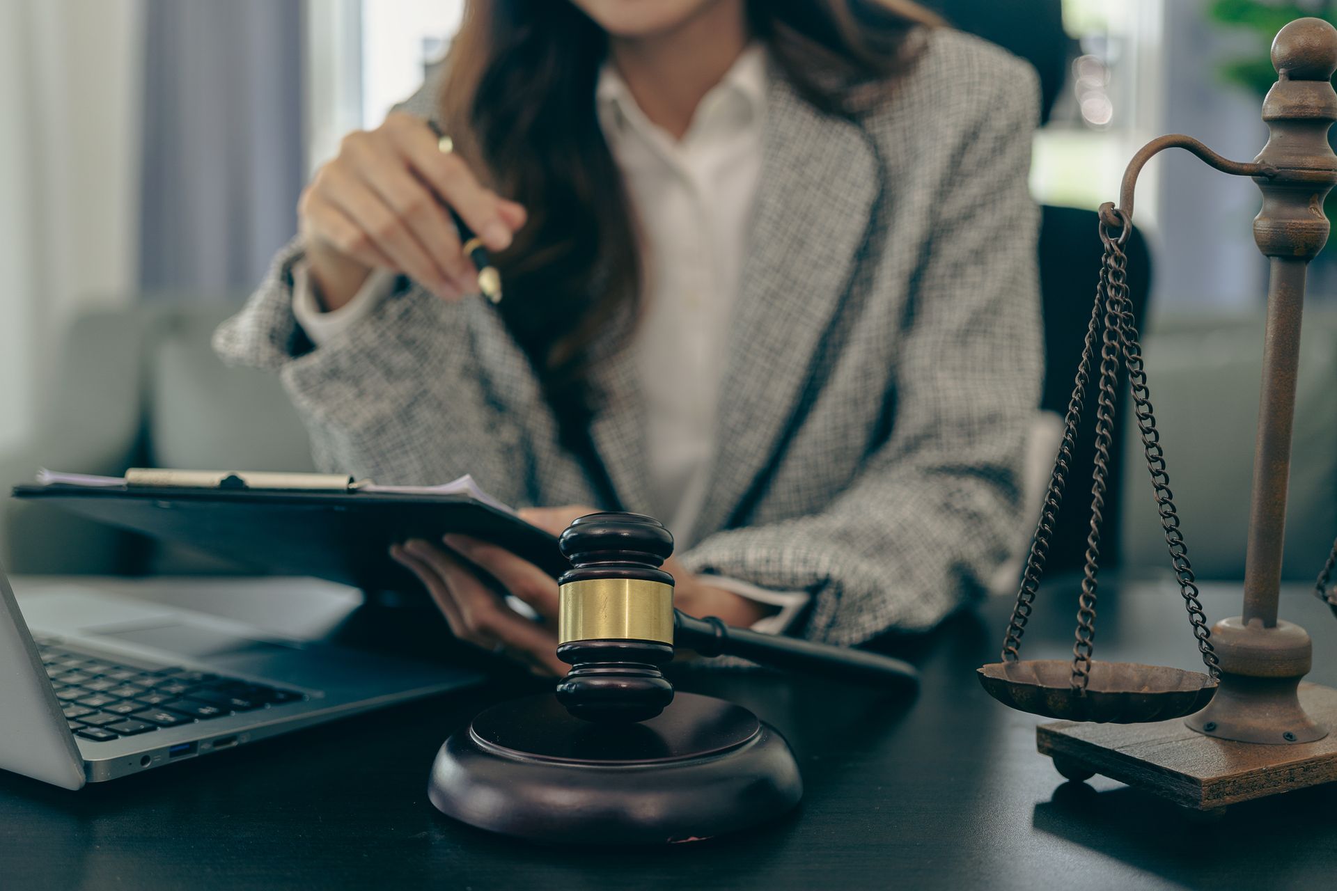 A lawyer is sitting at her desk reviewing a document.