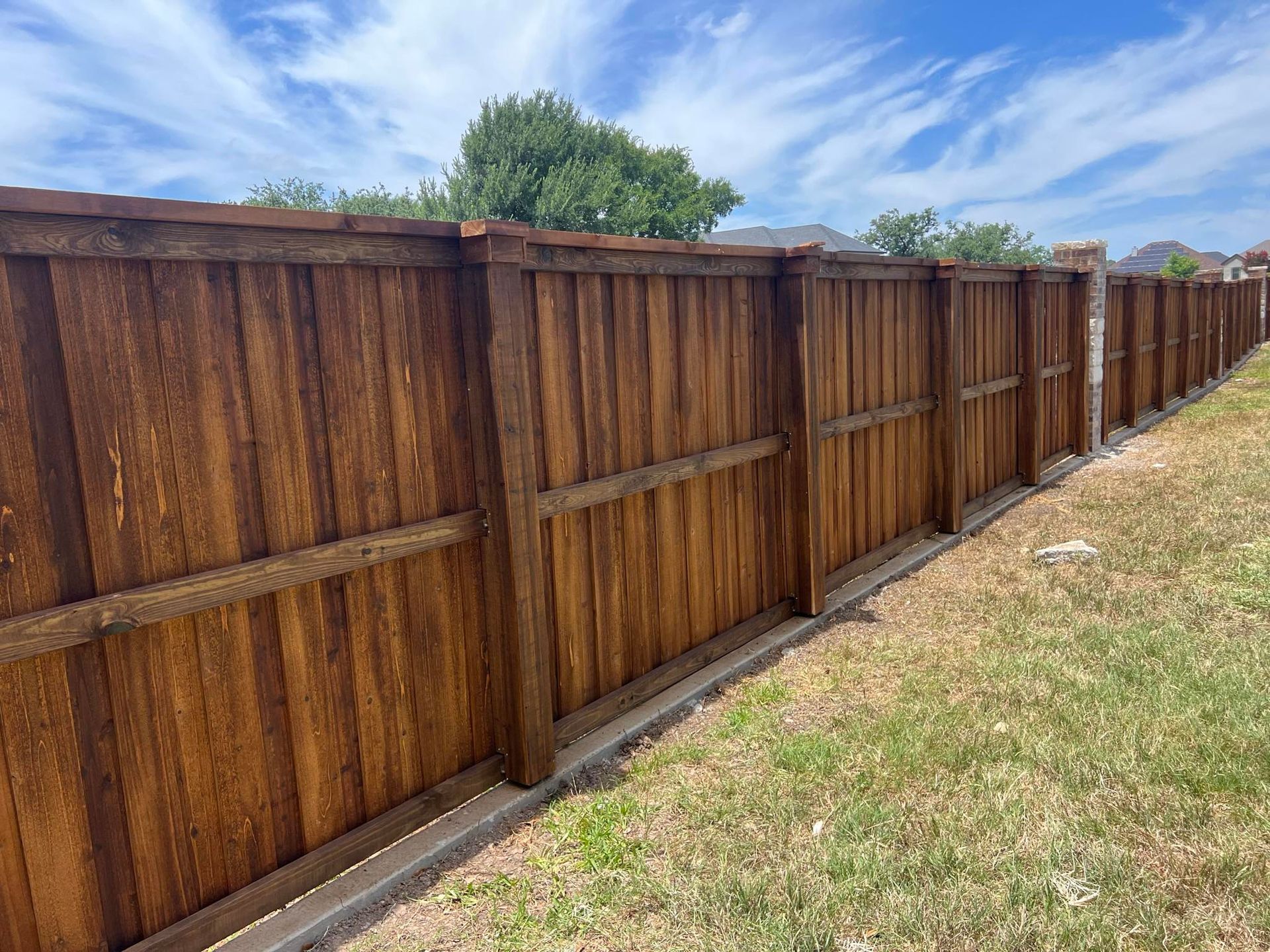 A wooden fence is sitting in the middle of a grassy field.