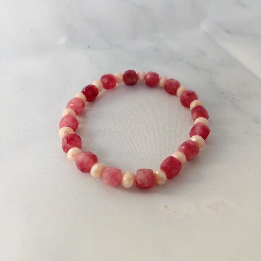 Armband van aardbeienkwartsblokkralen afgewisseld met roze facetkralen geregen op elastiek.