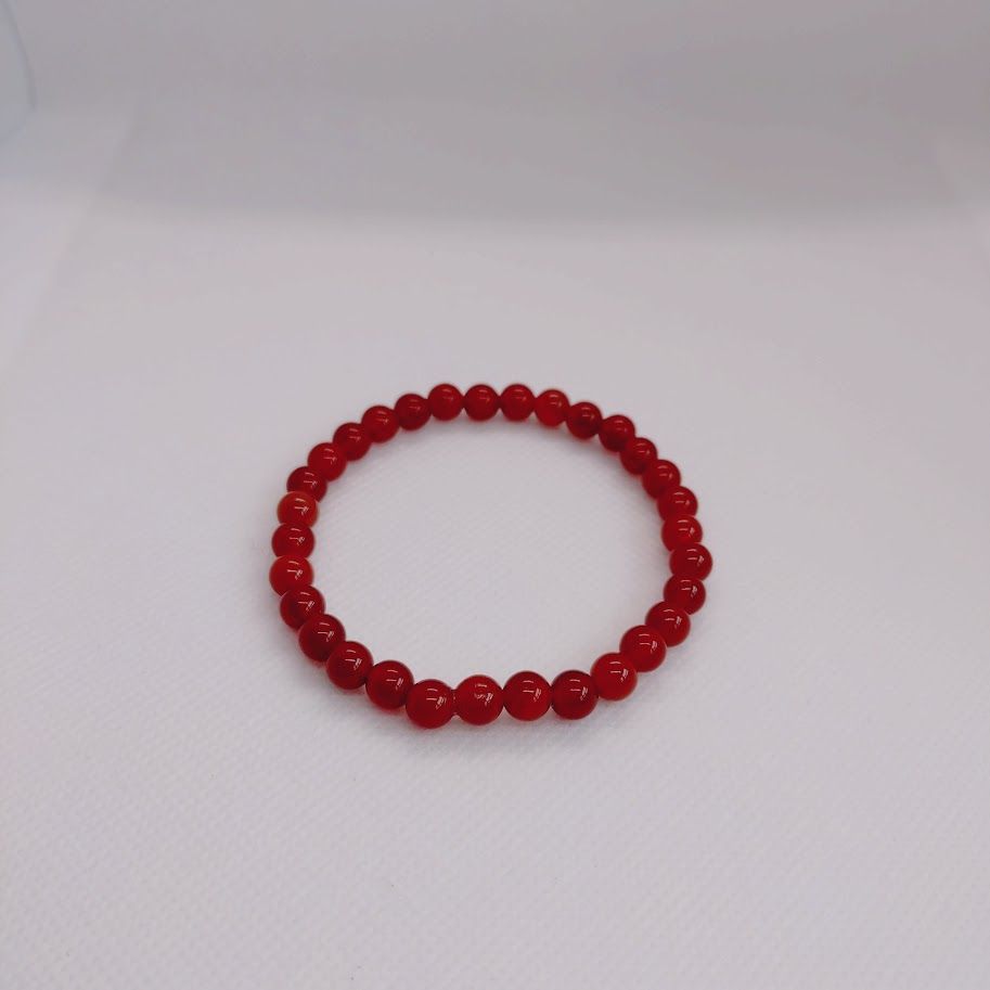 Armband van 6mm carneoolkralen geregend op elastiek.