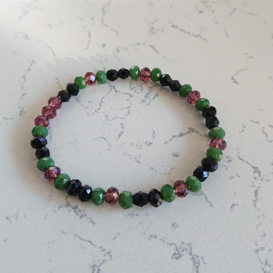 Armband op elastiek met 6mm facetkralen in een mooie kleurenmix van zwart, donkergroen en bordeaux