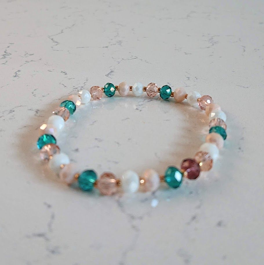 Armband met 6mm facetkralen in een mooi groen, rose en witte kleurenmix met gouden tussenkraaltjes.