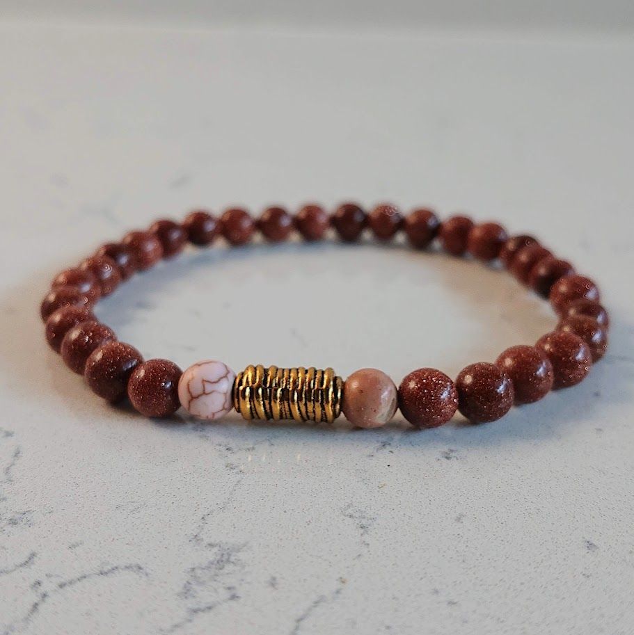 Armband van 6mm goudsteenkralen met een gouden stainless steel spiraal tussenkraal