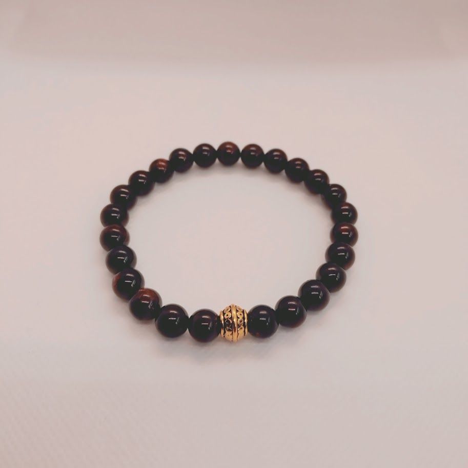 Armband van granaatkralen met goudkleur tussenkraal geregen op elastiek.