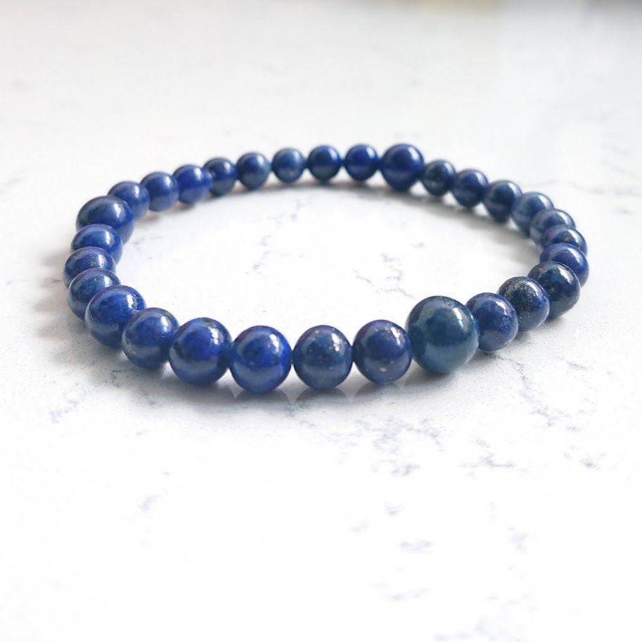 Armband op elastiek geregen van lapis lazulikralen van 6mm met daartussen drie kralen van 8mm.