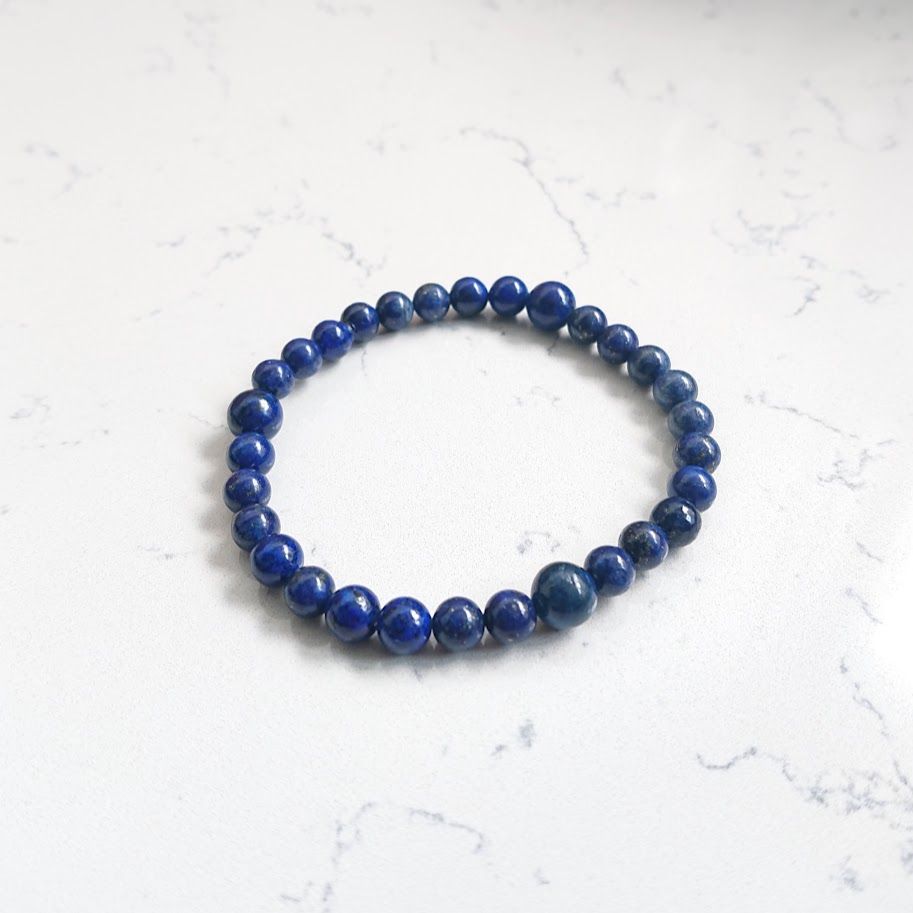 Armband op elastiek geregen van lapis lazulikralen van 6mm met daartussen drie kralen van 8mm.