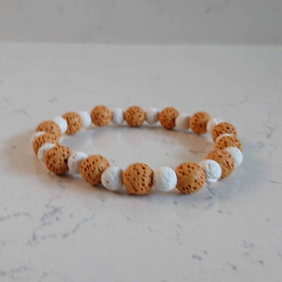Mooie armband van lavasteenkralen in de kleuren caramel en wit. Geschikt voor aromatherapie.