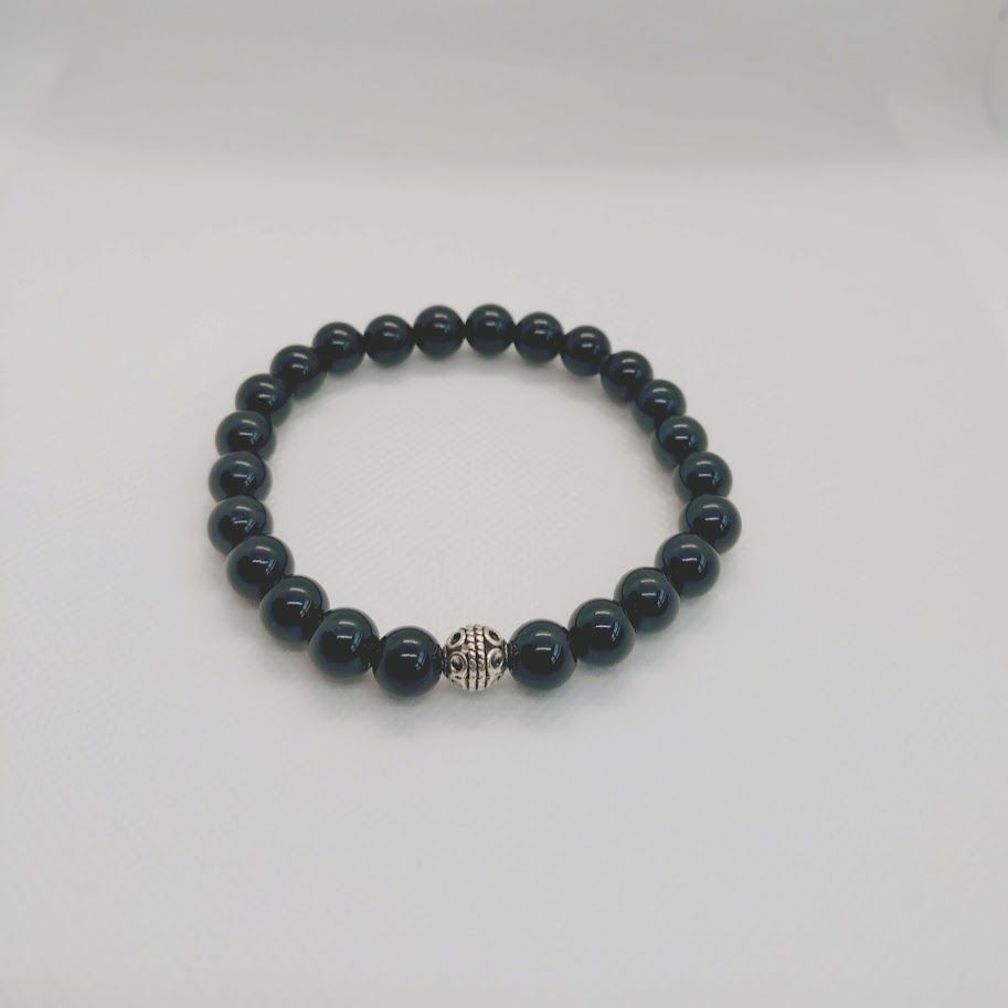 Armband van obsidiaankralen met zilverkleur tussenkraal geregen op elastiek.