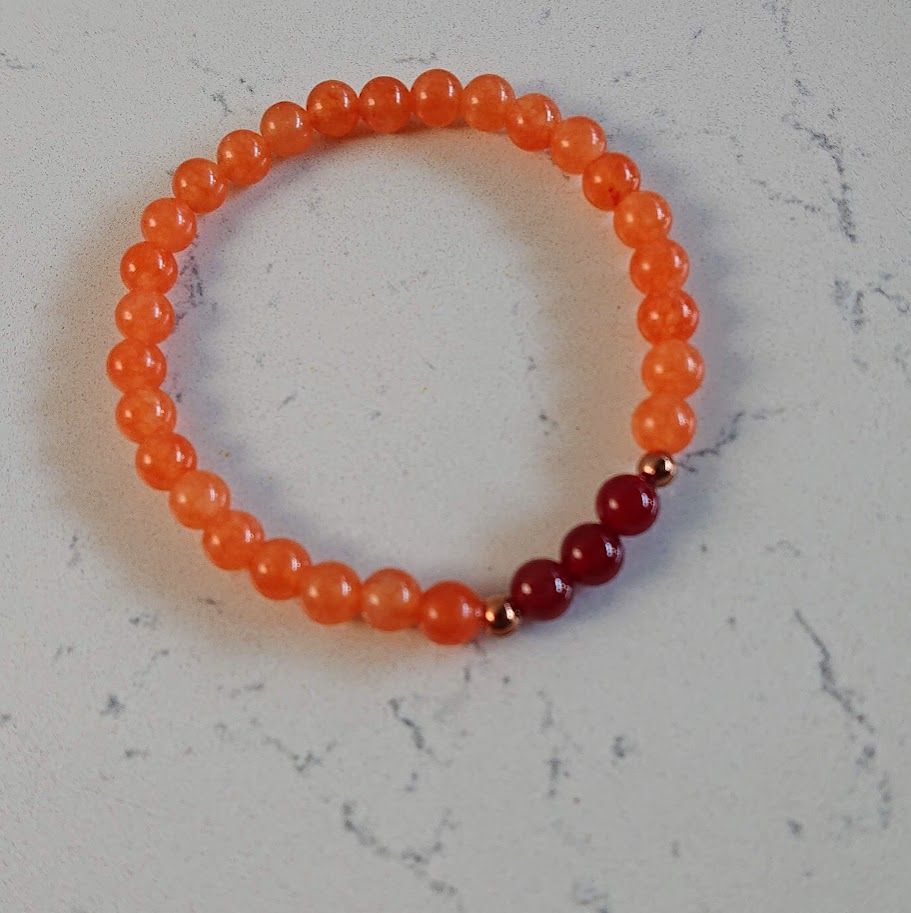 Armband op elastiek van 6mm perzik aventurijn en carneoolkralen en kleine gouden stainless steel tussenkraaltjes