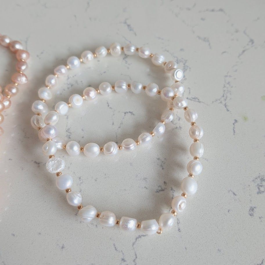 Witte zoetwaterparel armband met gouden tussenkralen