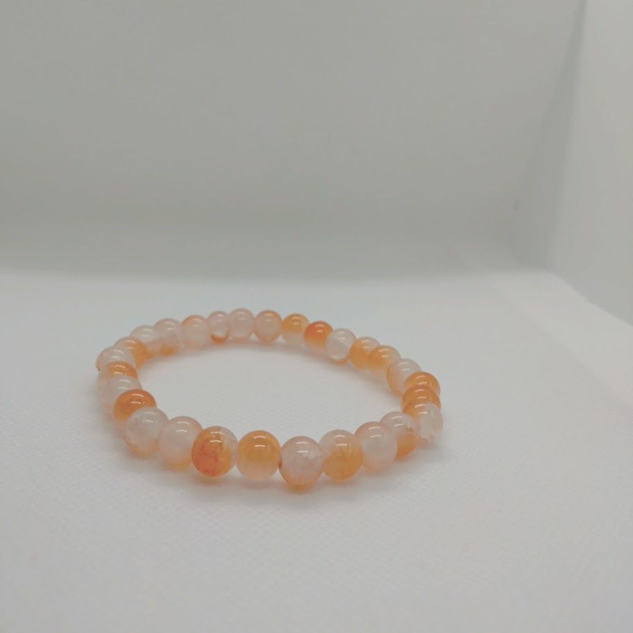 Armband van zonnesteenkralen geregen op elastiek.