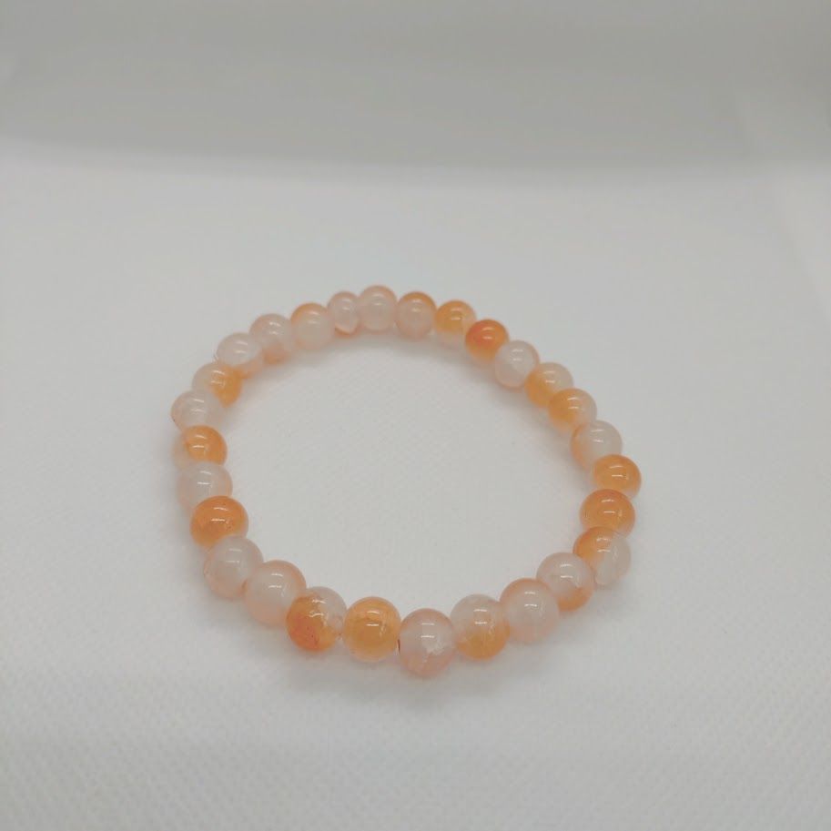 Armband van zonnesteenkralen geregen op elastiek.