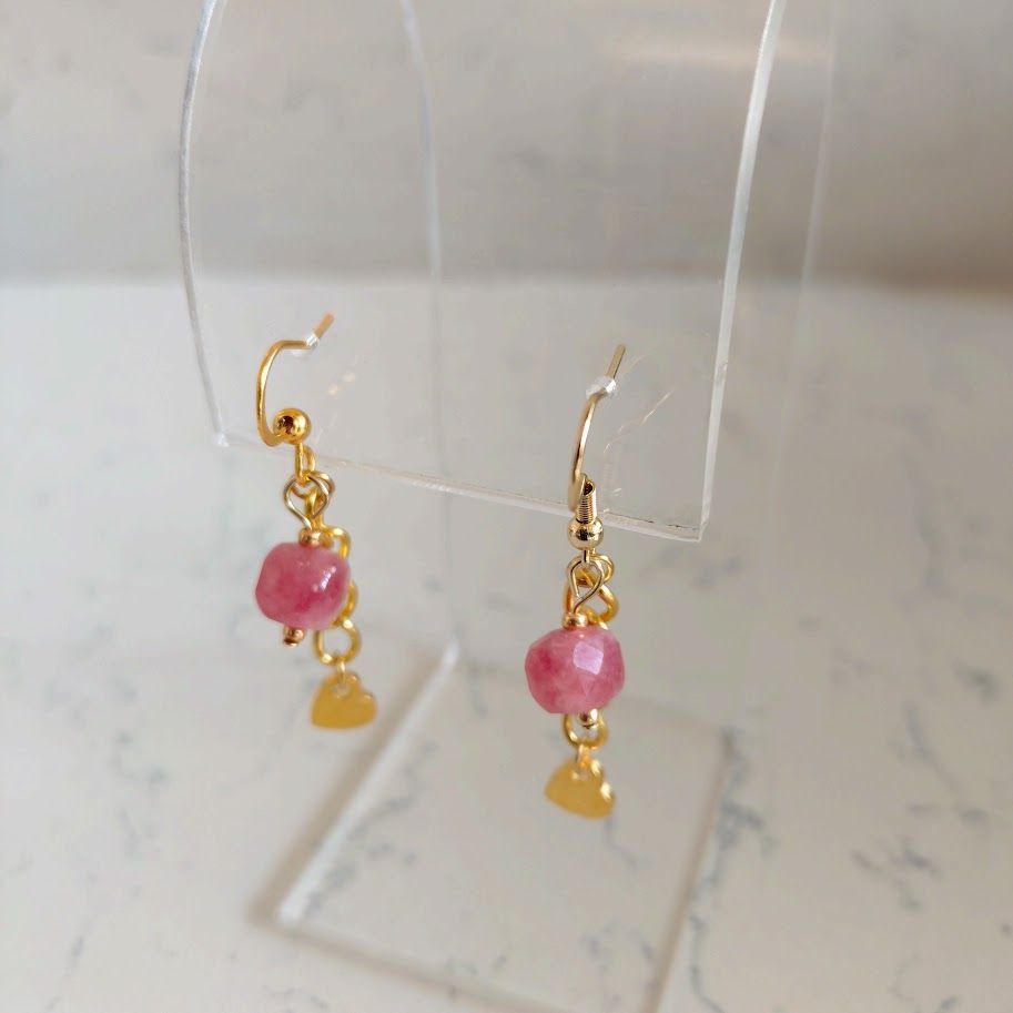 Oorbellen met een goudkleur schakelkettinkje met een hartjesbedel en aardbeienkwarts blokkralen.