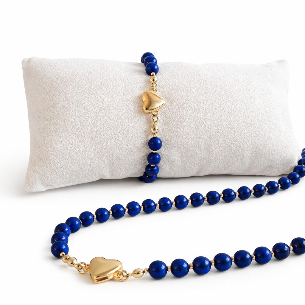 Sieradenset met lapis lazuli kralen en goudkleurige hart magneetsluiting: ketting, armband en oorbellen op witte achtergrond