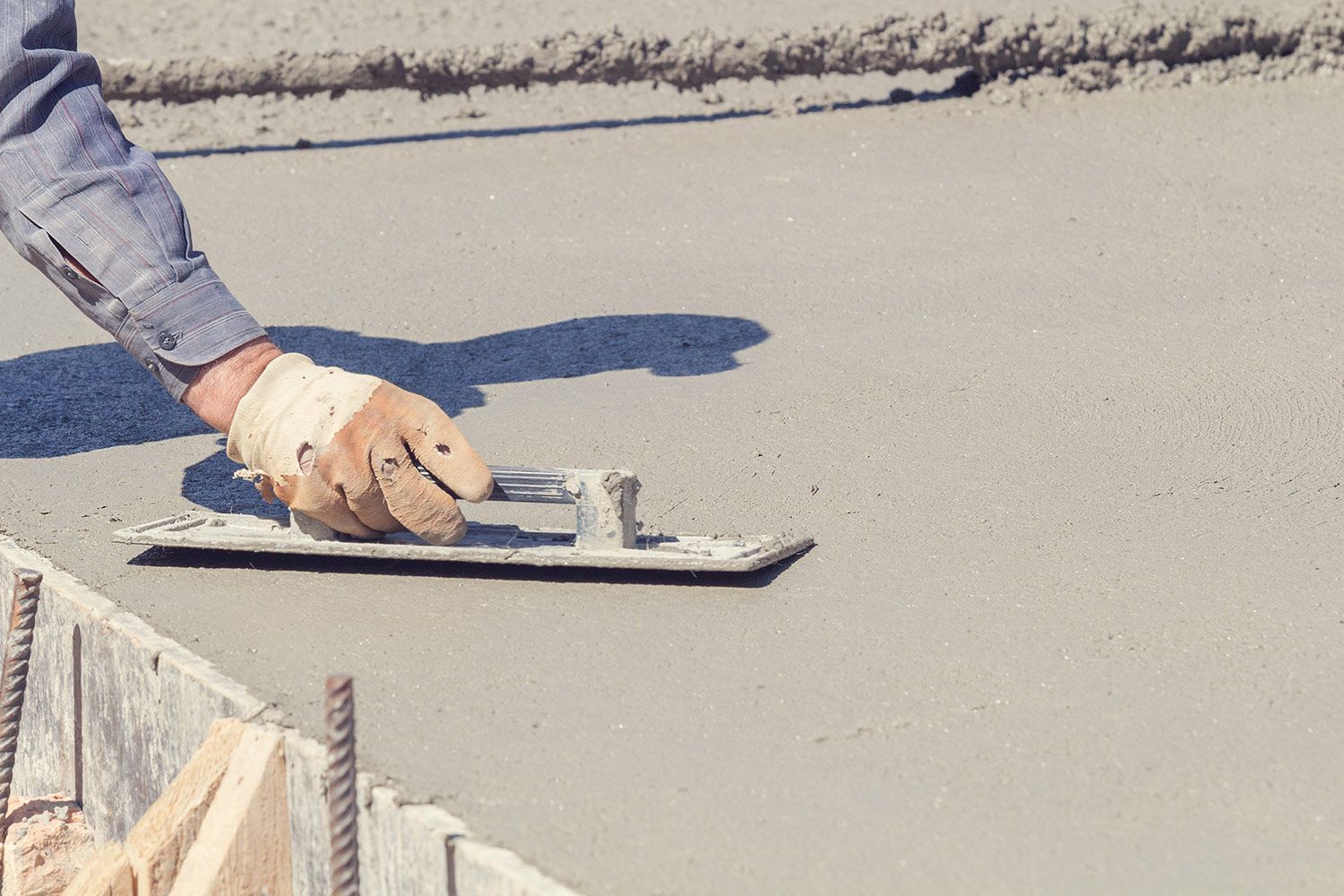 Worker leveling the wet concrete