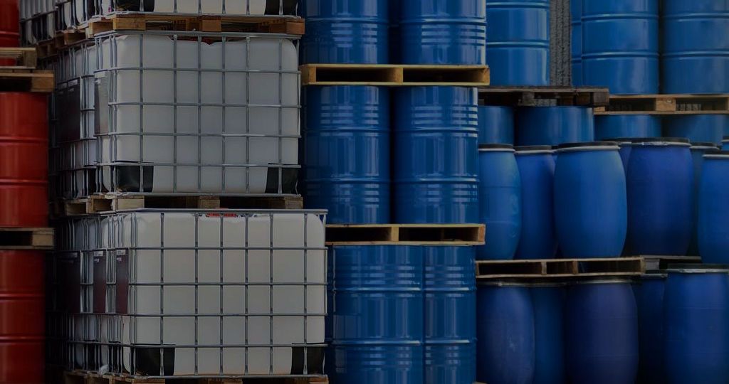 A bunch of barrels are stacked on top of each other on pallets.