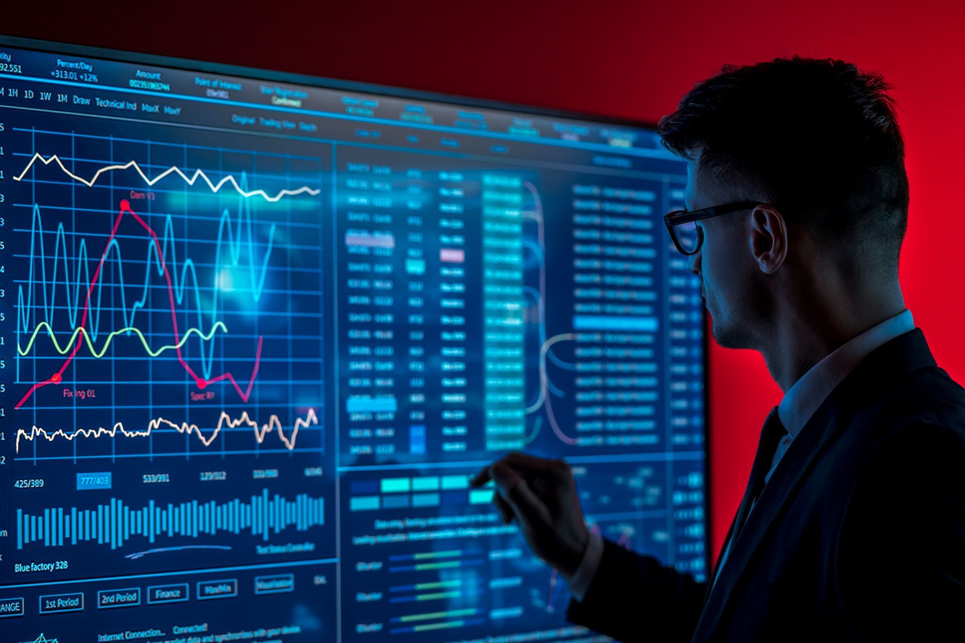 Man in glasses analyzing data on a large screen with charts and graphs. Red background.