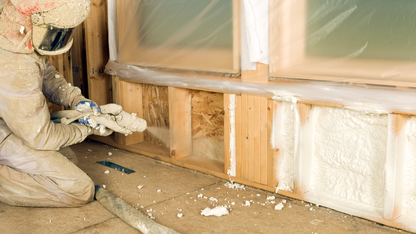 Professional technician spraying spray foam insulation onto attic panels, equipped with protective mask and gear for a safe and efficient installation in County Limerick.