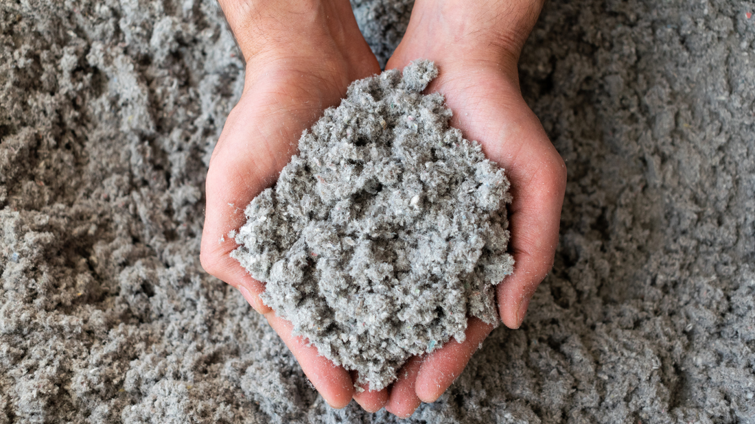 Hands holding cellulose insulation particles, showcasing eco-friendly, recycled material used for energy-efficient and sustainable home insulation in County Limerick.