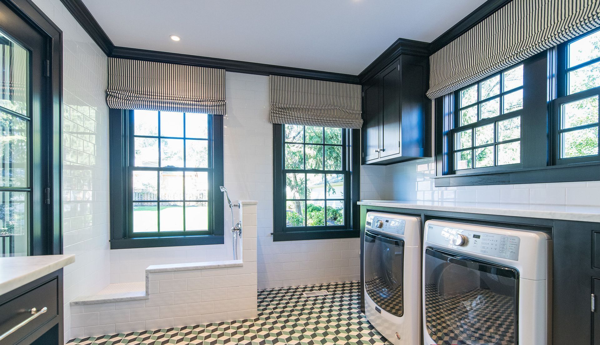 A laundry room with a washer and dryer and a bathtub.