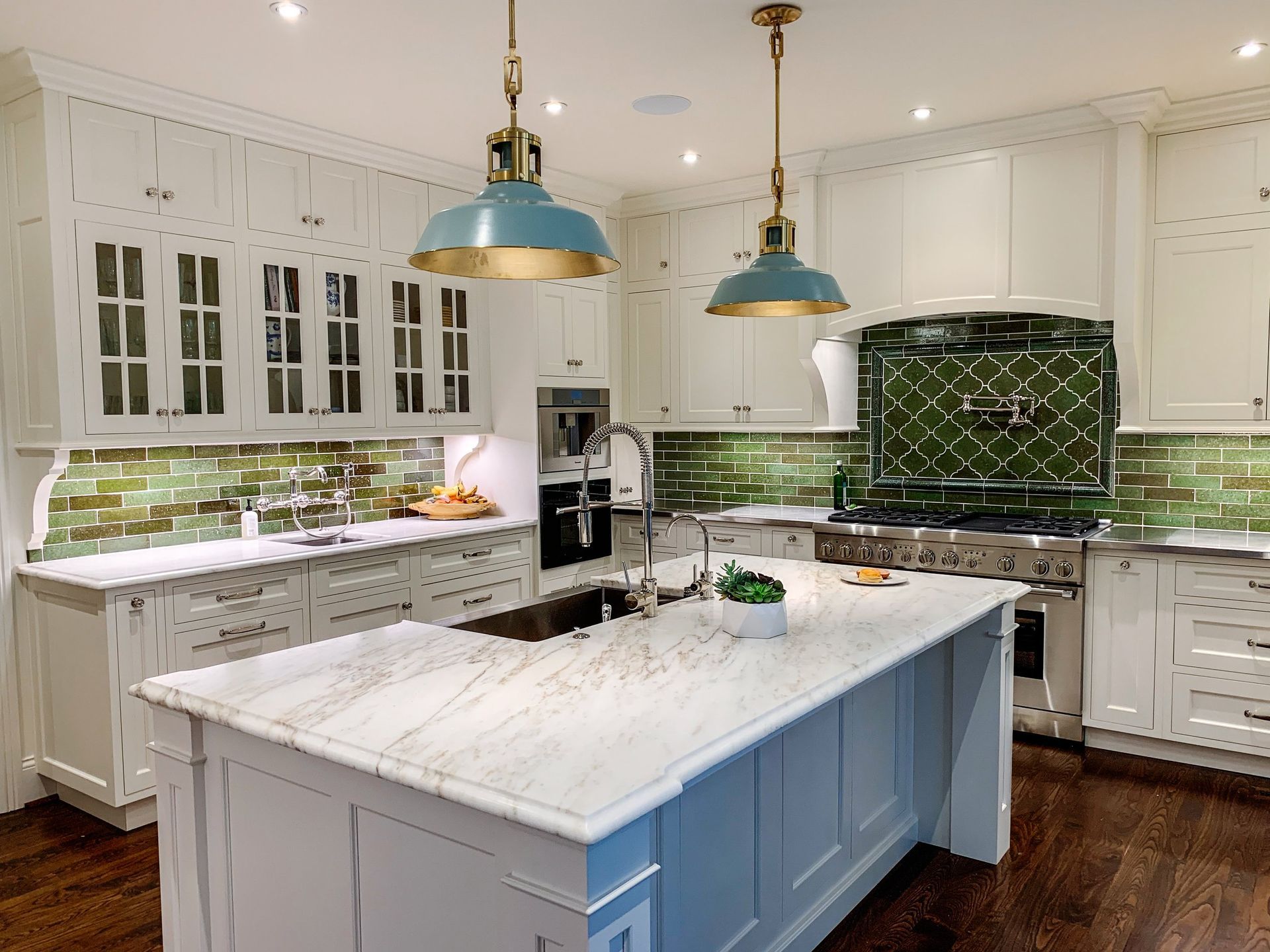 A kitchen with white cabinets and a large island in the middle.