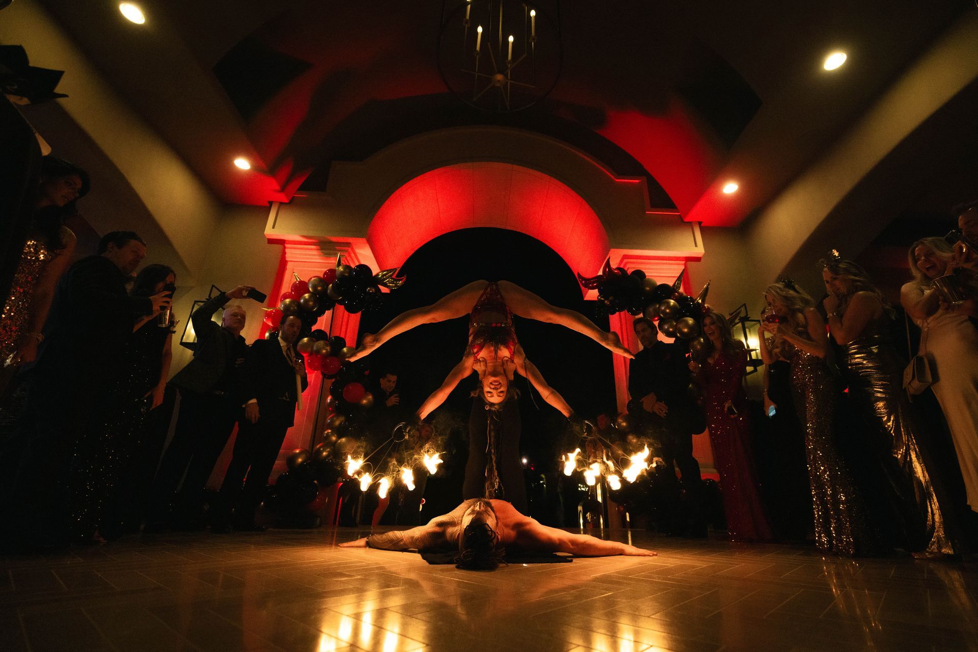 A woman is doing a handstand on feet on a stage in front of a crowd