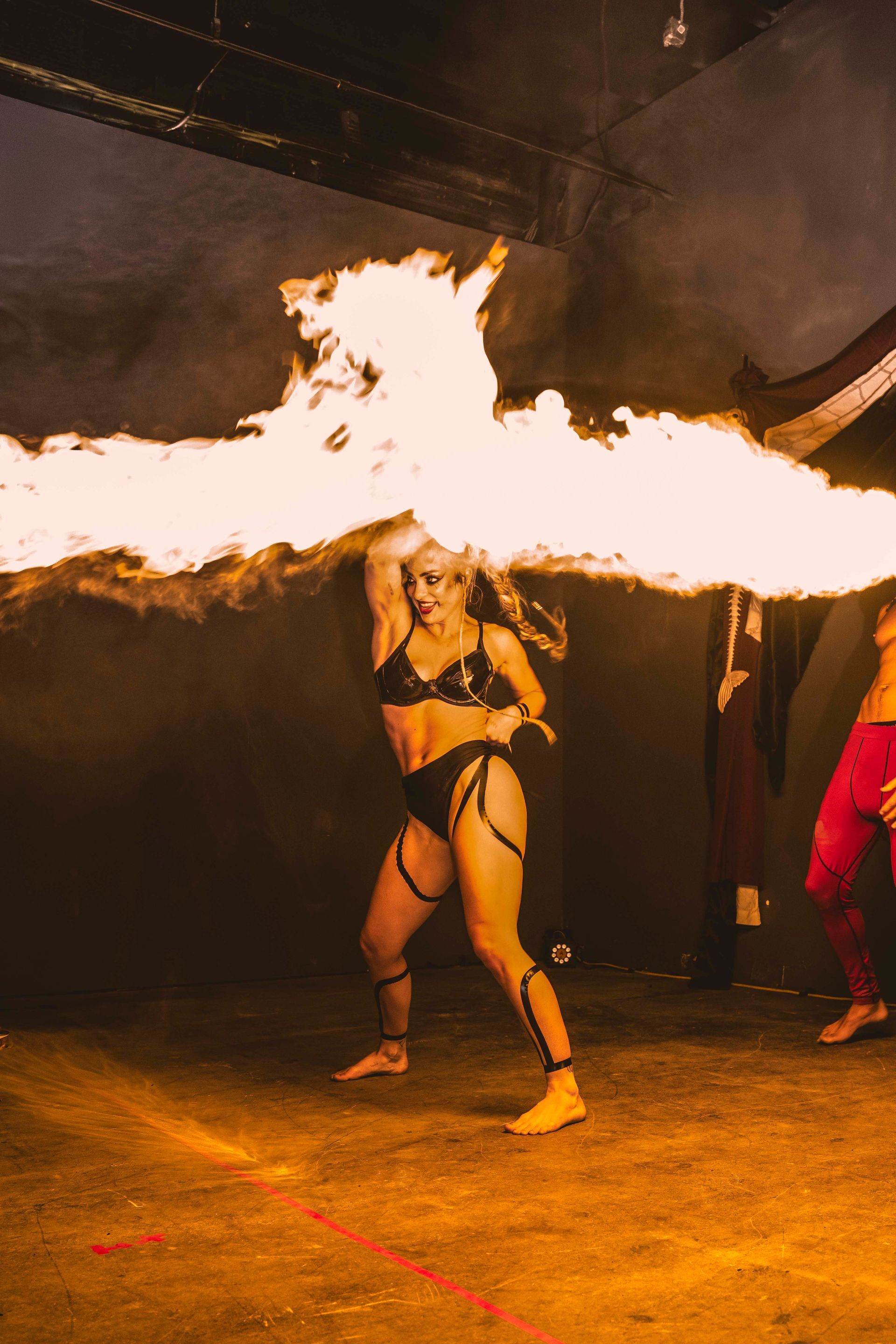 A woman performing with large fire effects.