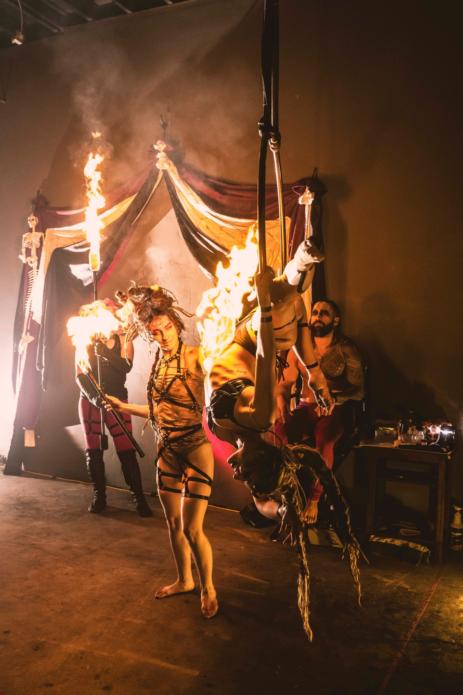 A group of people are standing in front of a tent with flames coming out of it.
