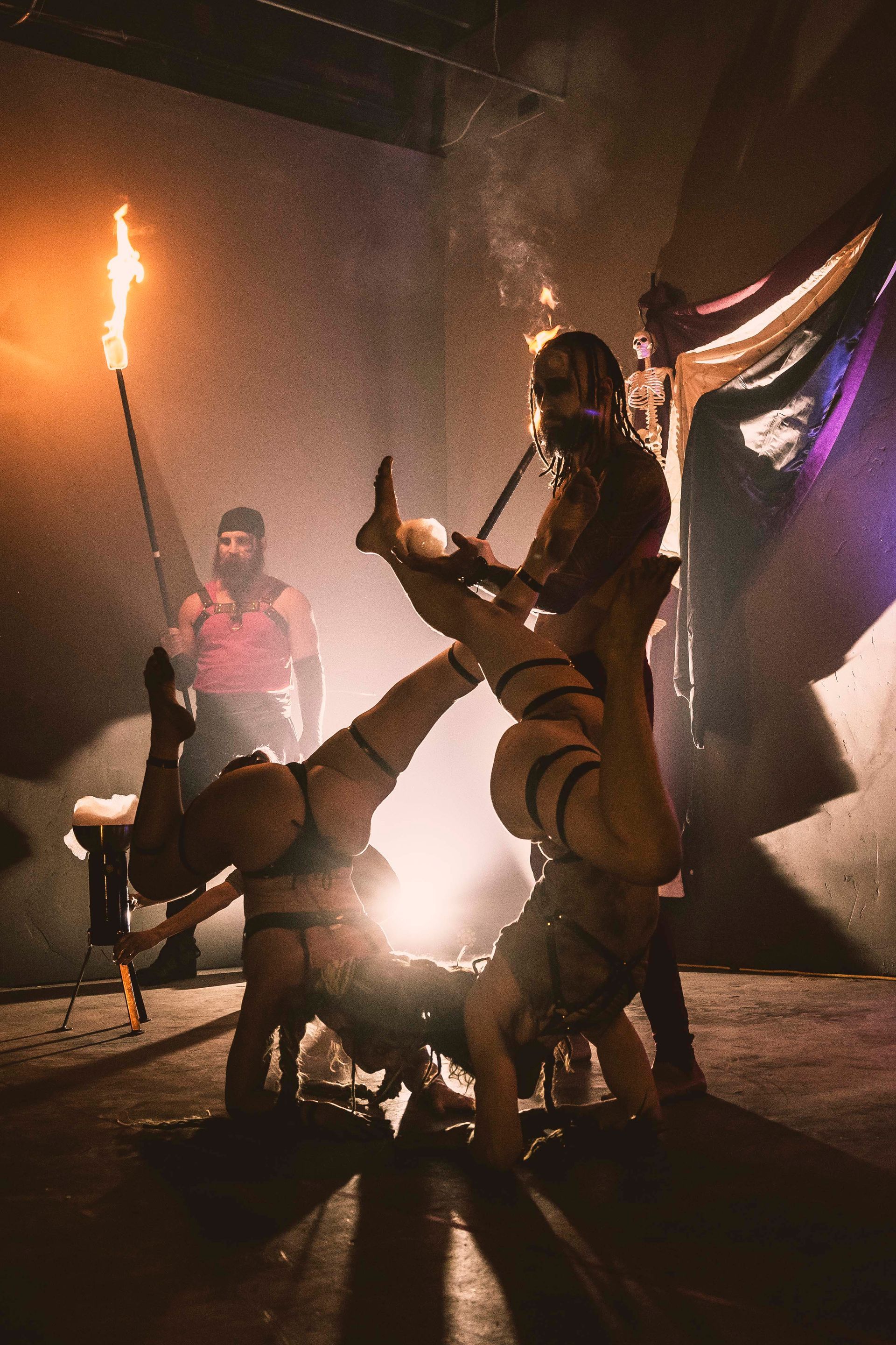 A man performing with two women on stage.