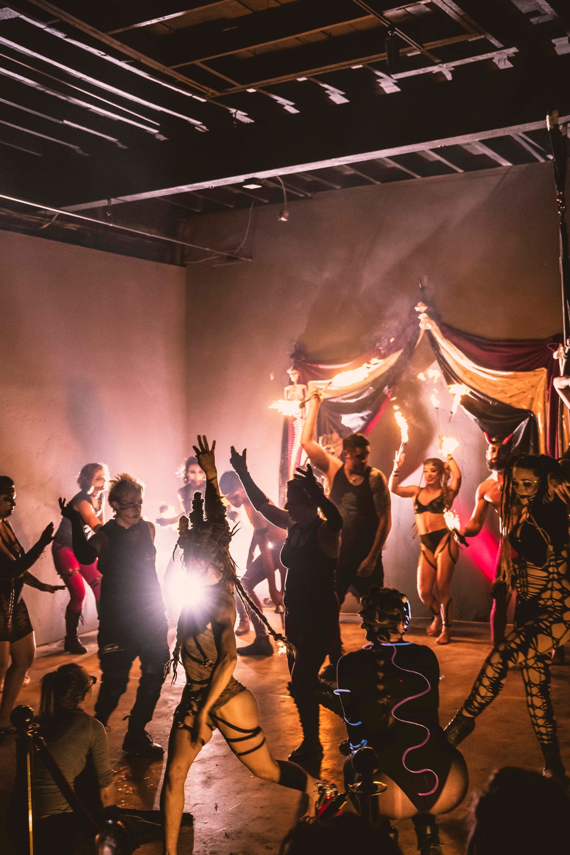 A group of performers dancing together at a Haunted Fire Circus.