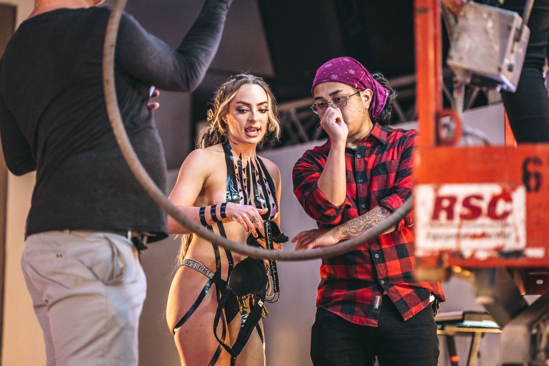 A man in a plaid shirt is standing next to a woman in a bikini.
