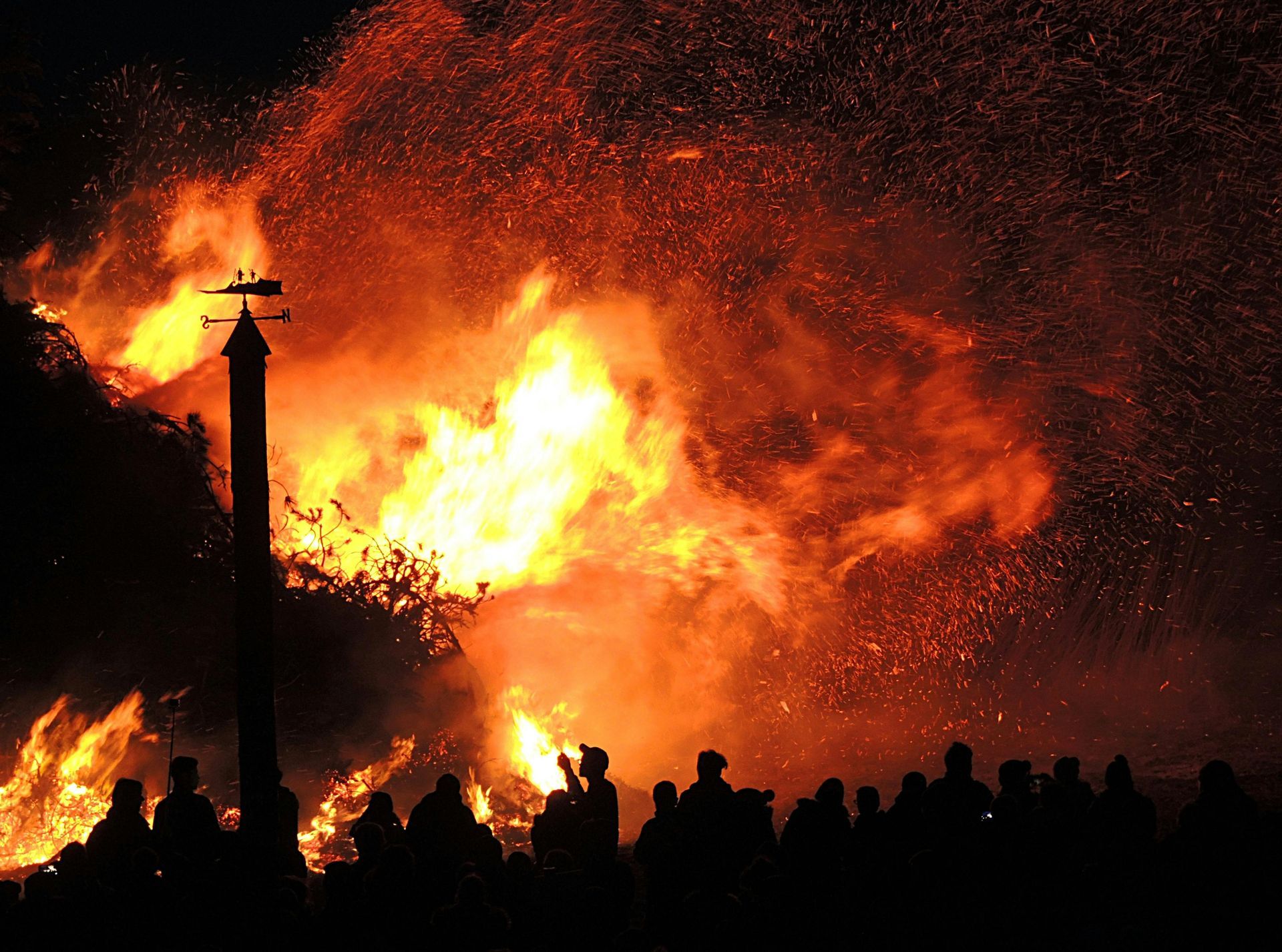 A group of people standing in front of a large fire