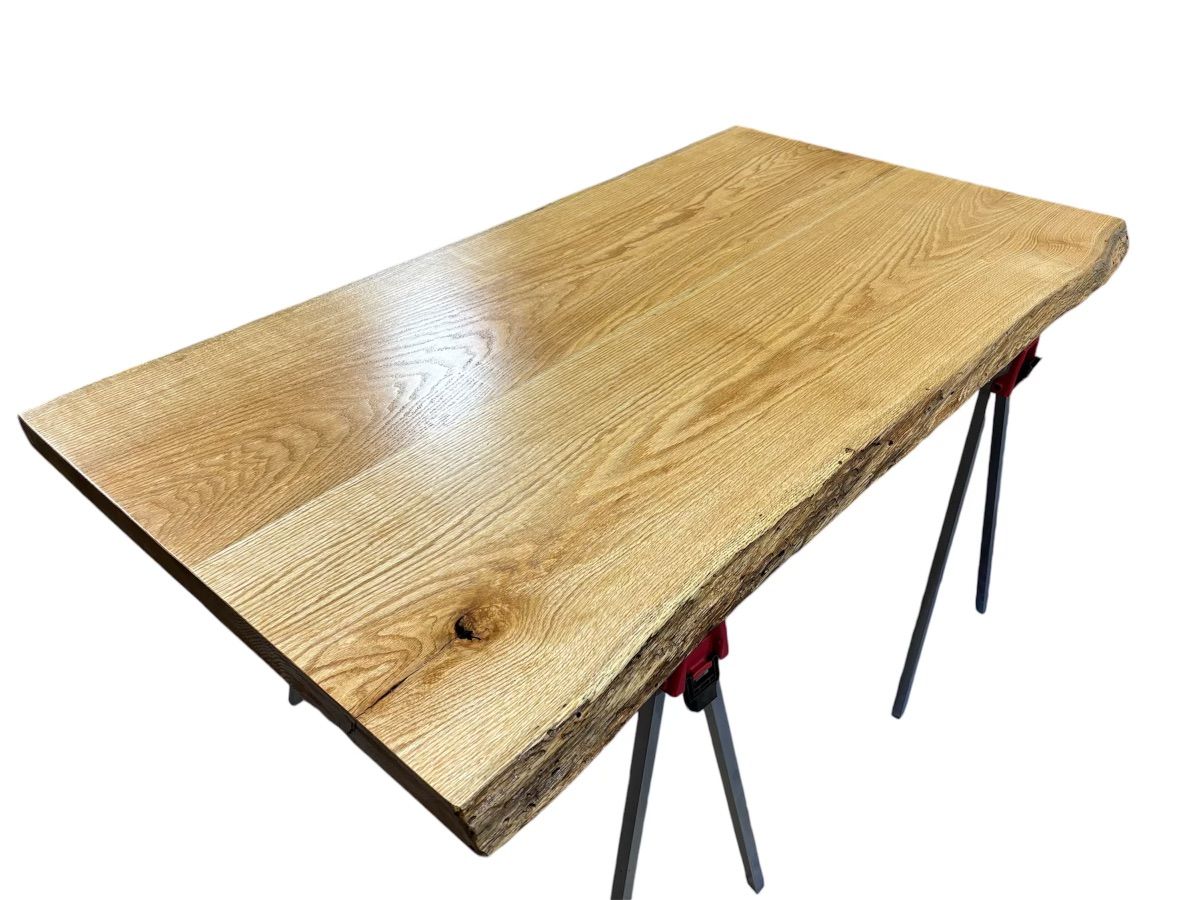 A wooden table is sitting on red clamps on a white background.