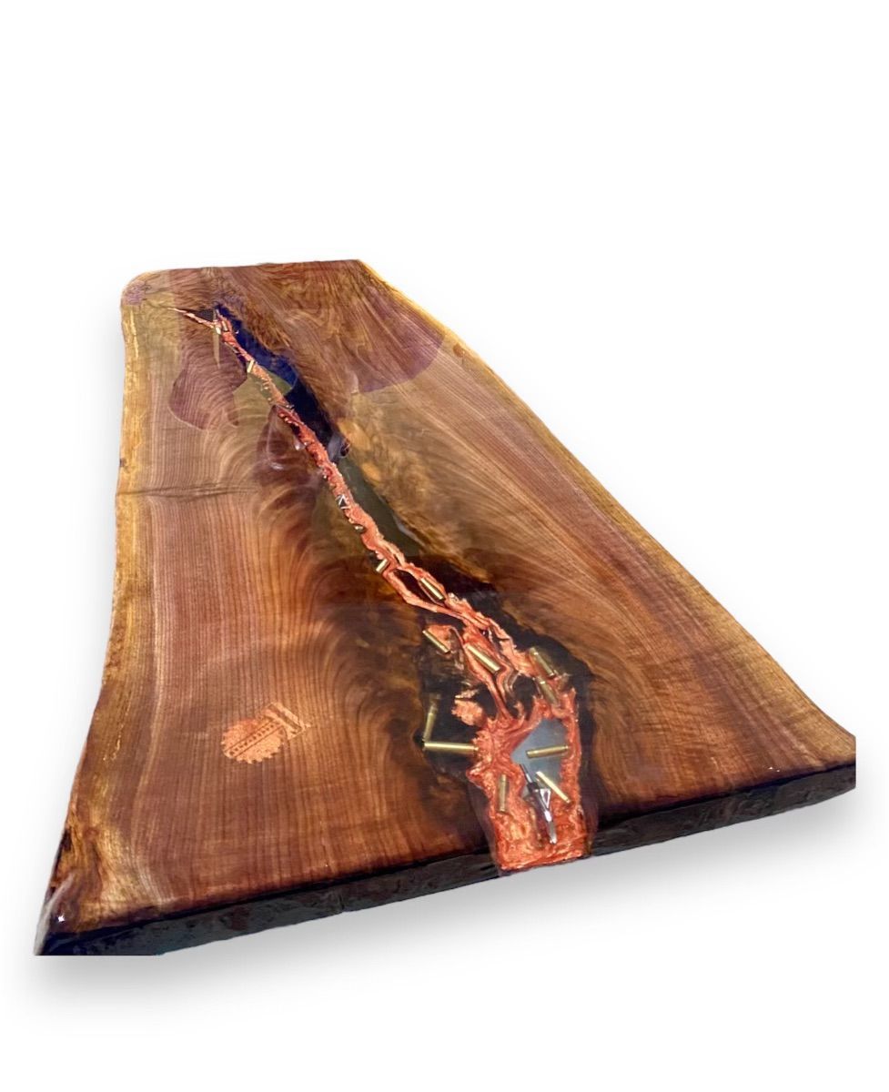 A custom made live edge table with a clear epoxy inlay that display brass ammunition casings