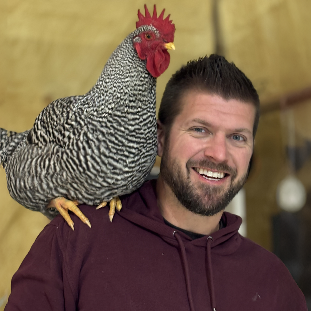 Jordan Timmerman, the owner of Timmberman's Woodworking with a rooster on his shoulder