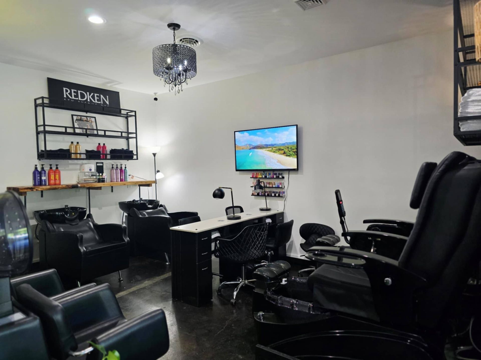 Hair salon interior with styling chairs, wash stations, and a Reiken product display.