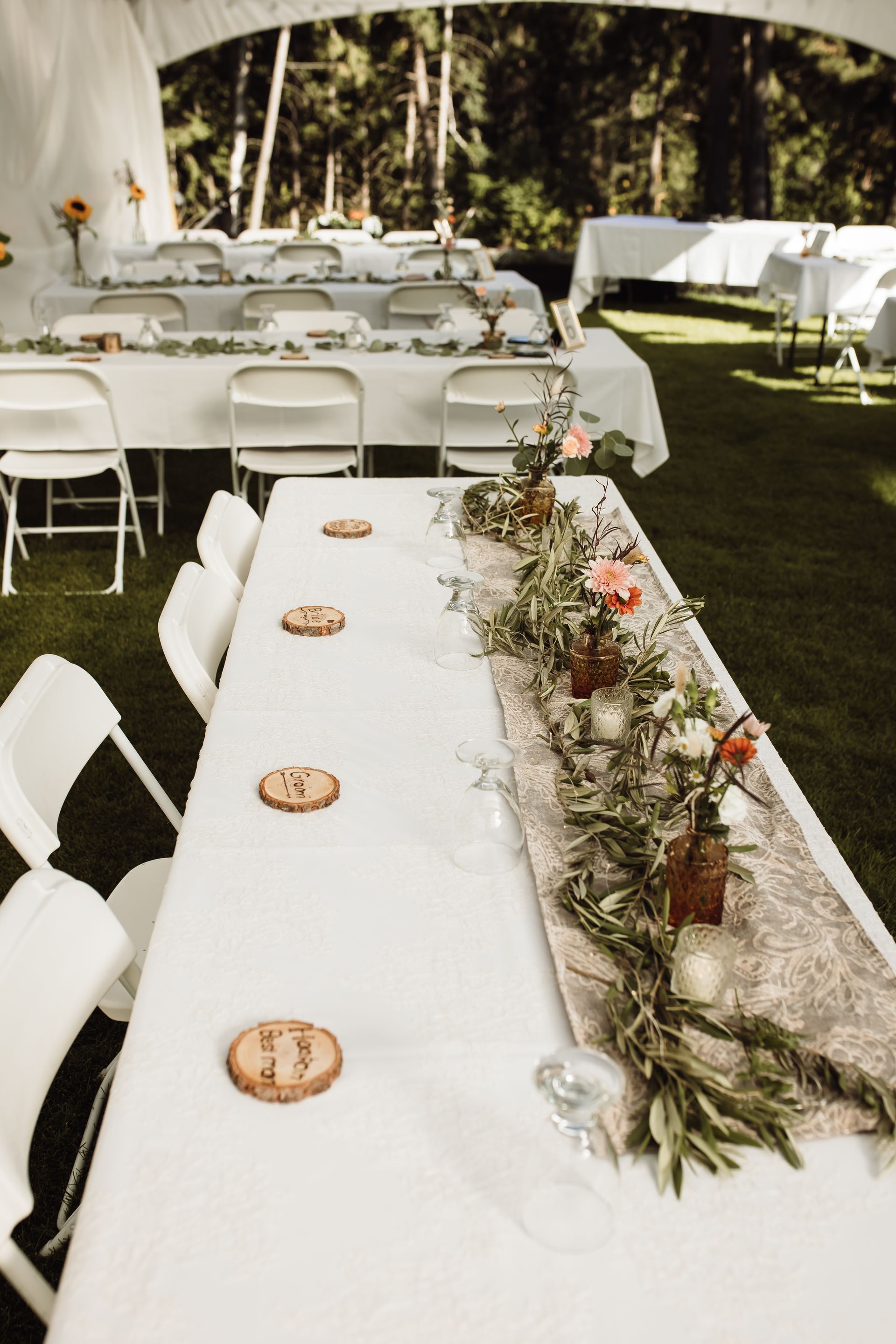 A long table is set up for a wedding reception under a tent.
