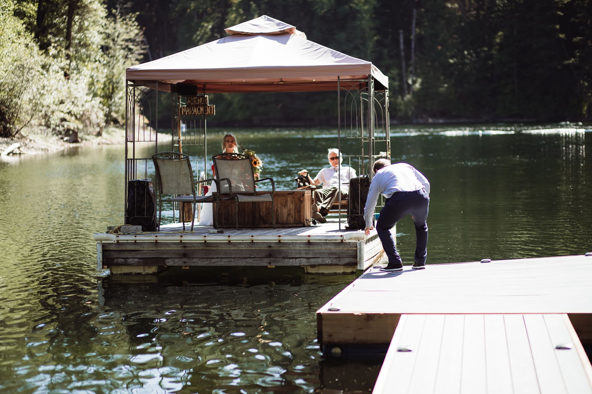 A man is standing on a dock next to a boat with a canopy over it