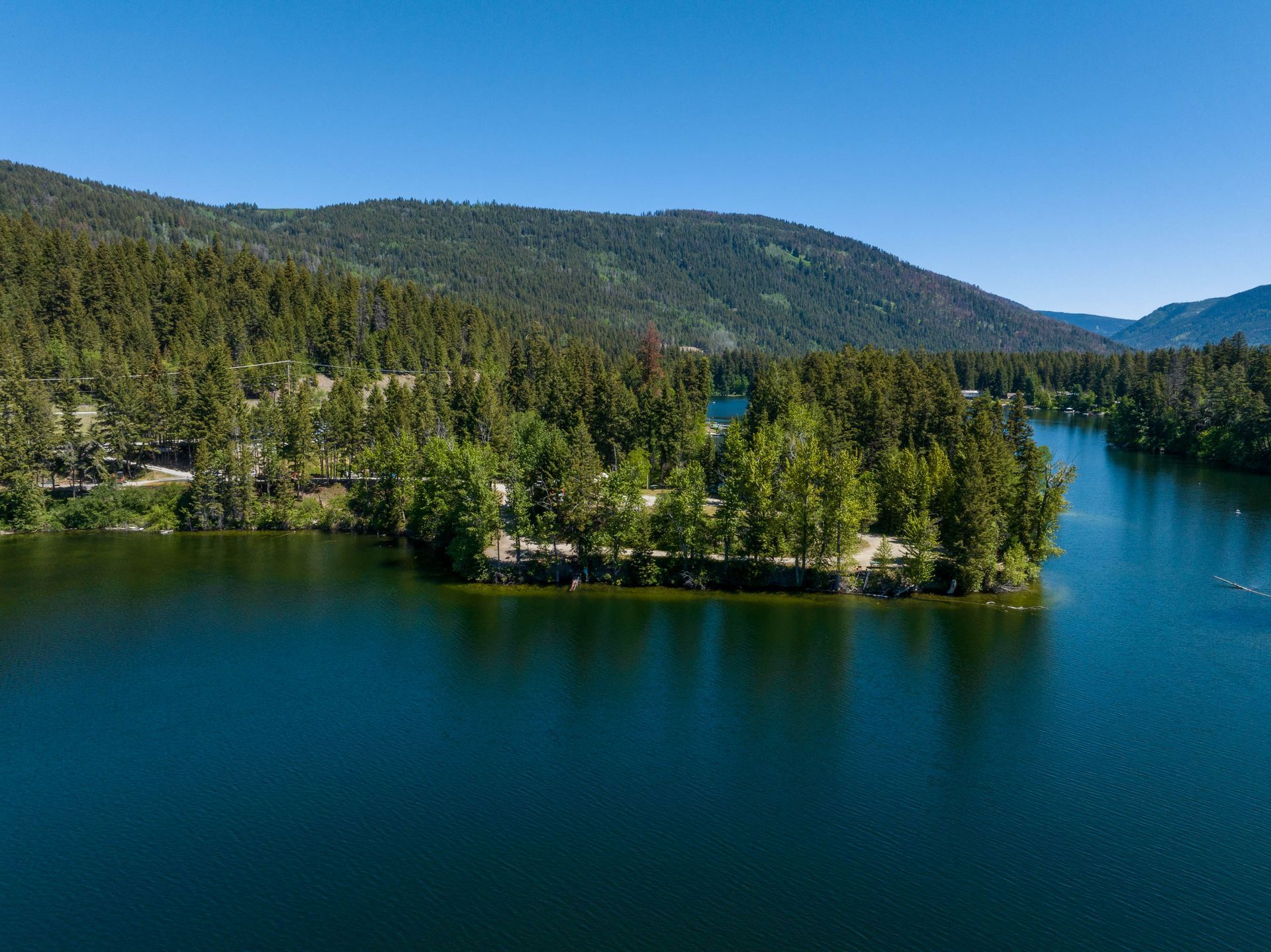 An aerial view of a lake with a small island in the middle surrounded by trees.