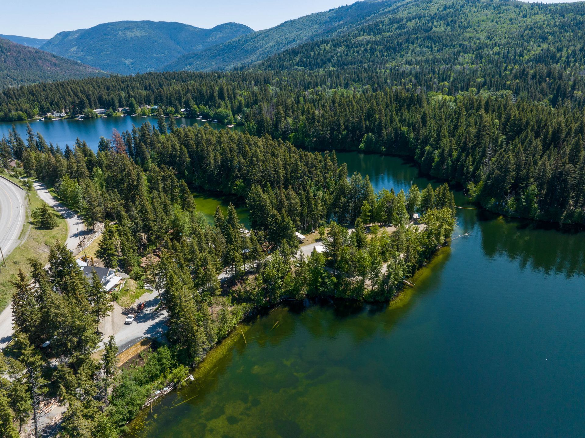 An aerial view of a lake surrounded by trees and mountains.
