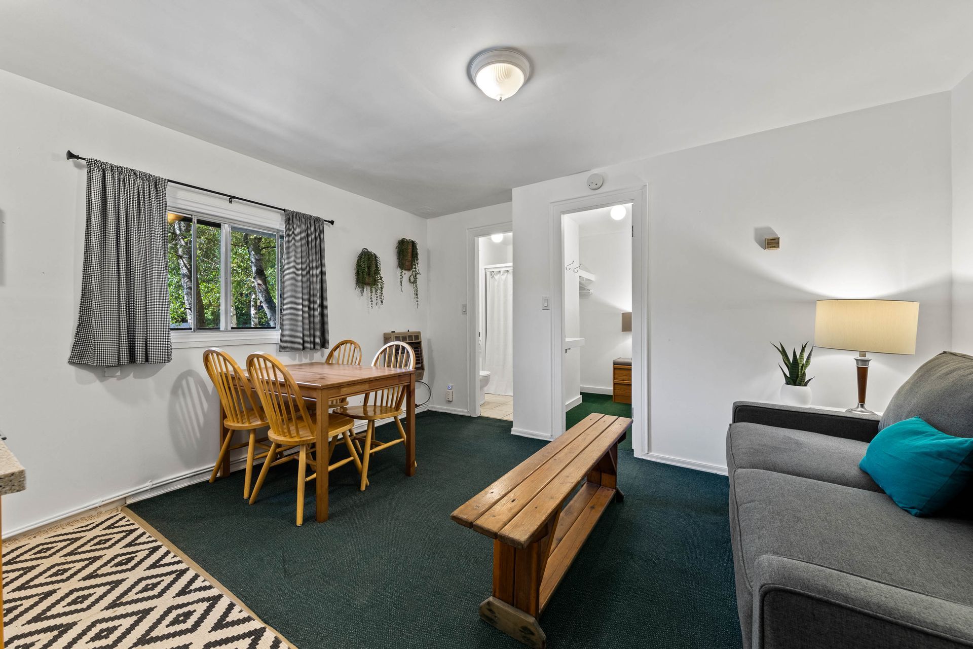 A living room with a couch , table and chairs.